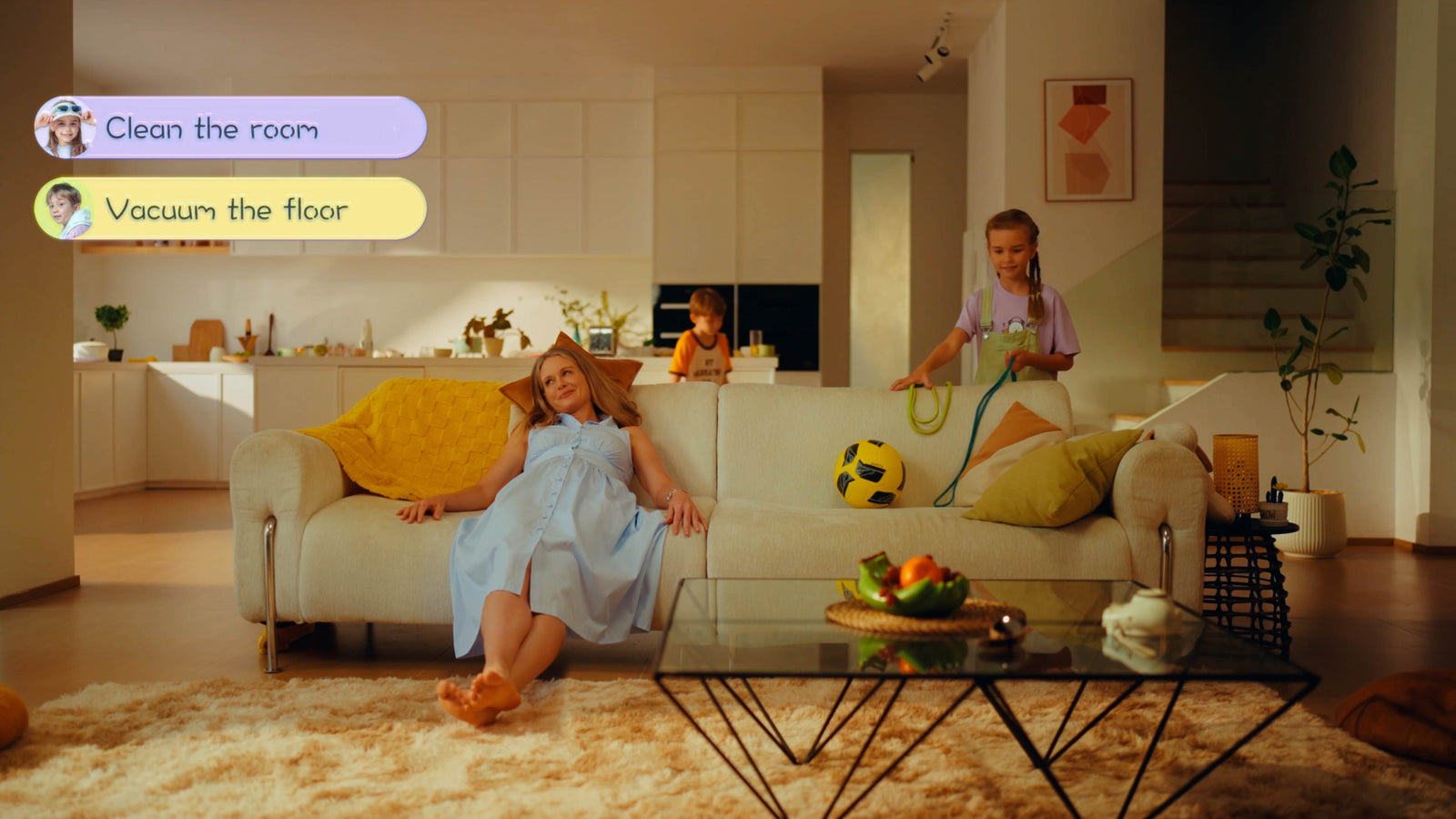 A relaxed mother resting on a couch while children carry out household chores managed by a digital family calendar.